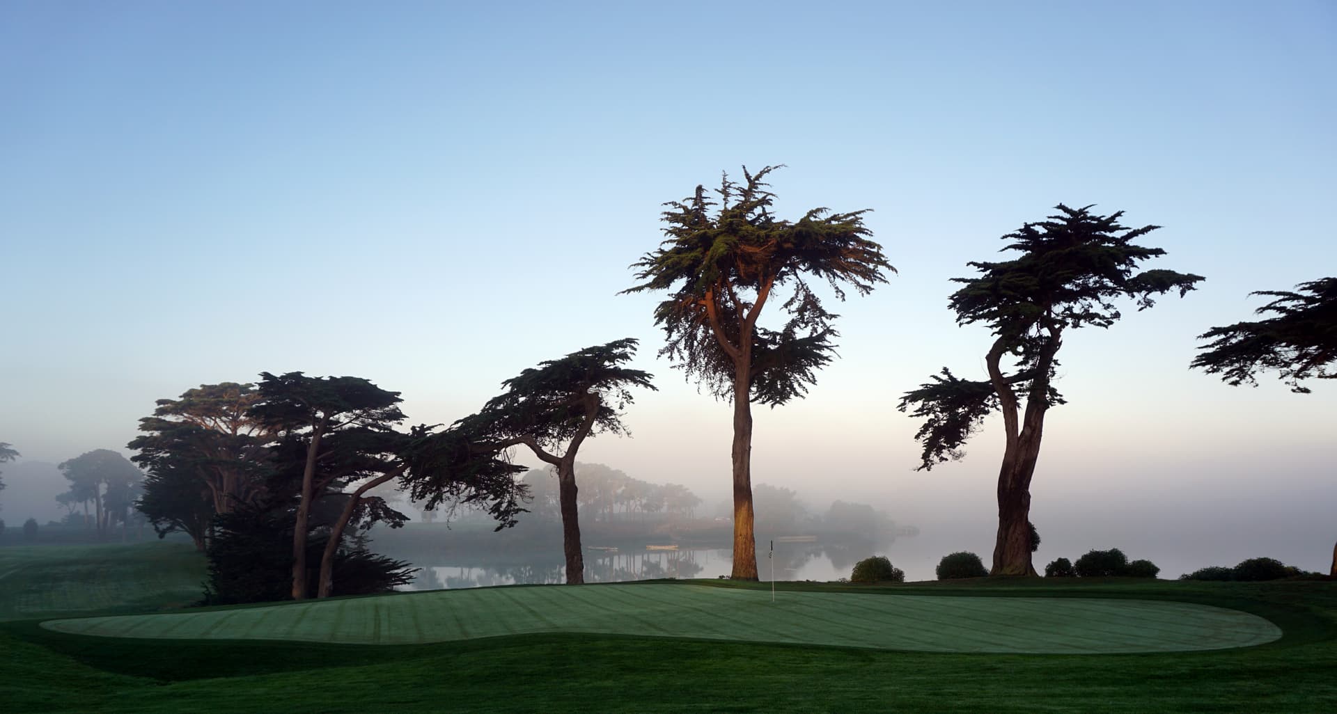 The 18th green at TPC Harding Park beside Lake Merced, San Francisco. Photo by Tinou Bao, licensed CC BY 2.0, via Wikimedia Commons/Flickr (commons.wikimedia.org/wiki/File:TPC_Harding_Park_-_18th_Green_(15332936118).jpg).